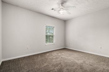Spacious Carpeted Bedroom With Ceiling Fan